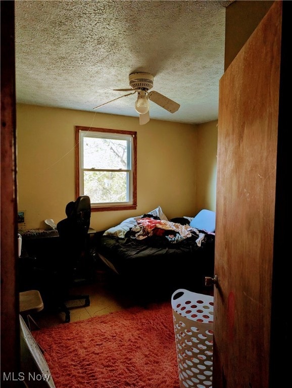 bedroom featuring a textured ceiling and ceiling fan