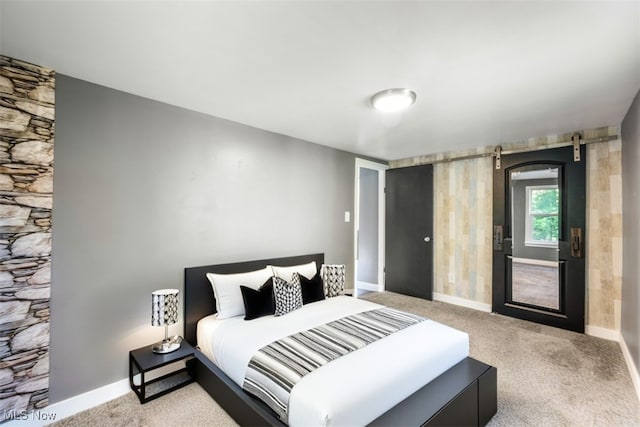 carpeted bedroom featuring a barn door