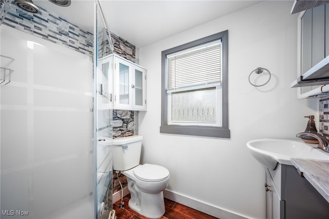 bathroom with hardwood / wood-style floors, vanity, a shower, and toilet