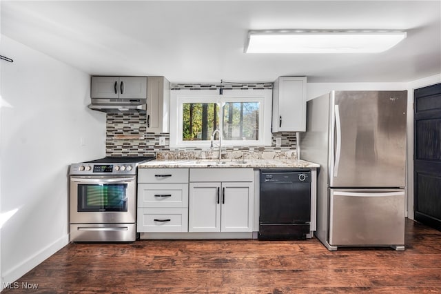 kitchen with dark hardwood / wood-style flooring, sink, stainless steel appliances, and tasteful backsplash