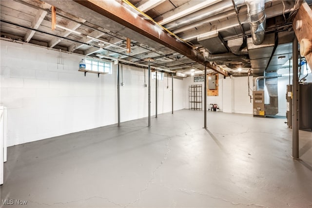 basement featuring electric panel and heating unit