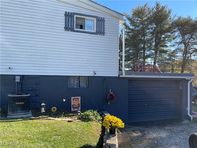 view of side of home featuring a balcony, a lawn, and central AC unit