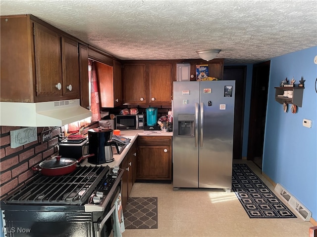 kitchen with ventilation hood, appliances with stainless steel finishes, dark brown cabinetry, and a textured ceiling