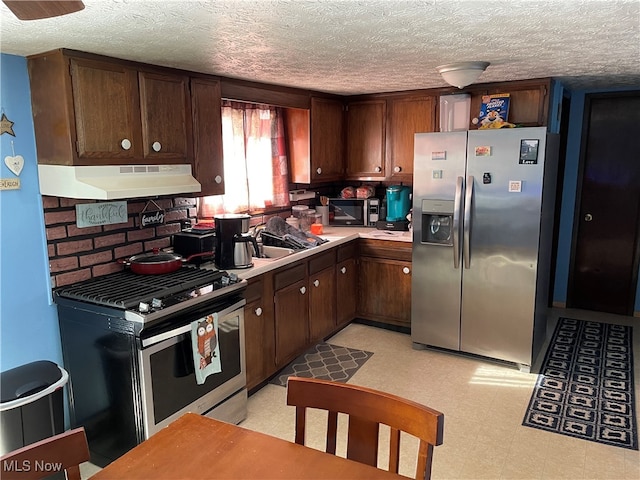 kitchen featuring sink, appliances with stainless steel finishes, dark brown cabinets, and a textured ceiling