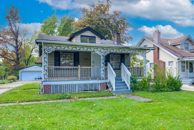 bungalow-style house featuring a porch, an outdoor structure, a front yard, and a garage