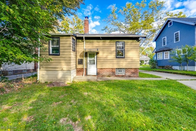 rear view of property with a yard