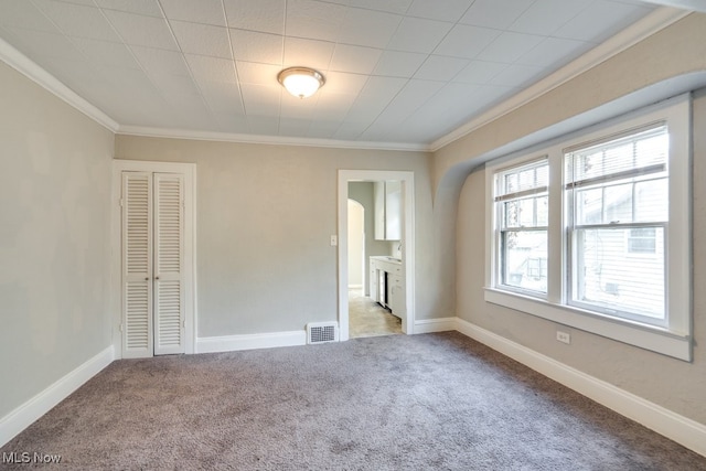 empty room featuring light carpet and ornamental molding