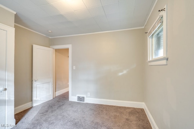 empty room with ornamental molding and carpet floors