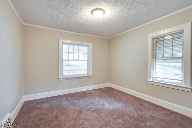 carpeted empty room with crown molding and a textured ceiling