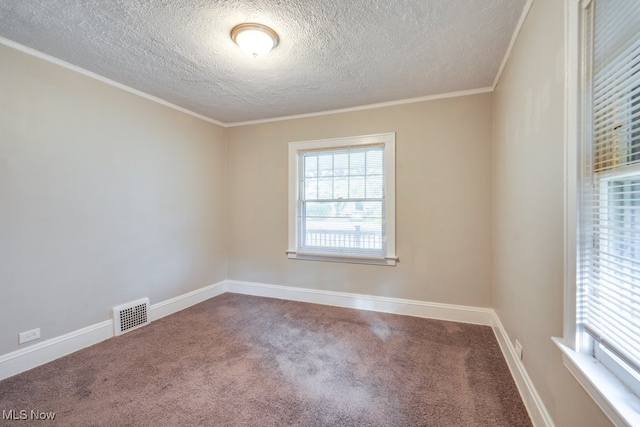 empty room with ornamental molding, a textured ceiling, and carpet