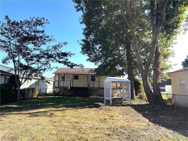 rear view of house featuring a lawn