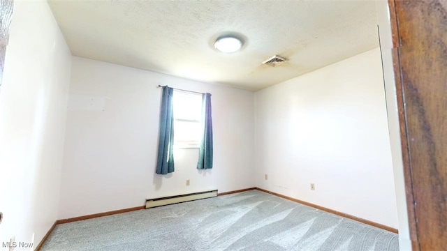 empty room with a baseboard radiator, light colored carpet, and a textured ceiling