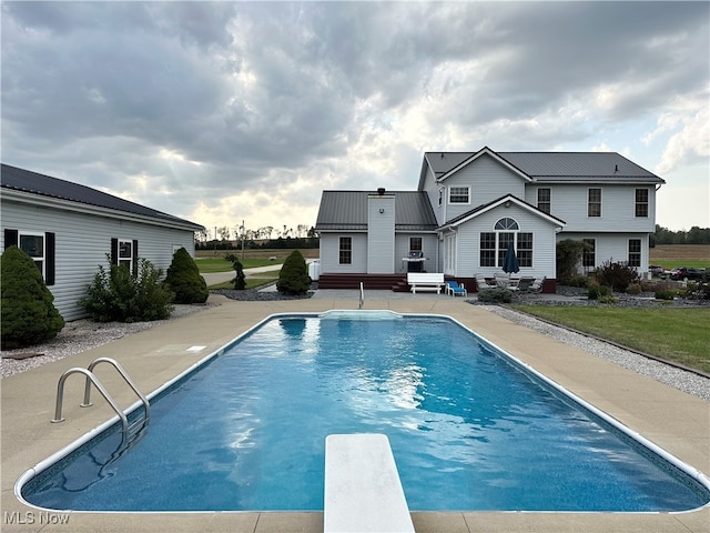 view of pool featuring a patio area and a diving board