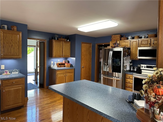 kitchen with appliances with stainless steel finishes and hardwood / wood-style flooring