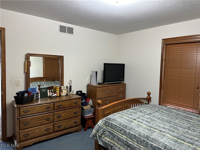 bedroom featuring a textured ceiling and carpet floors