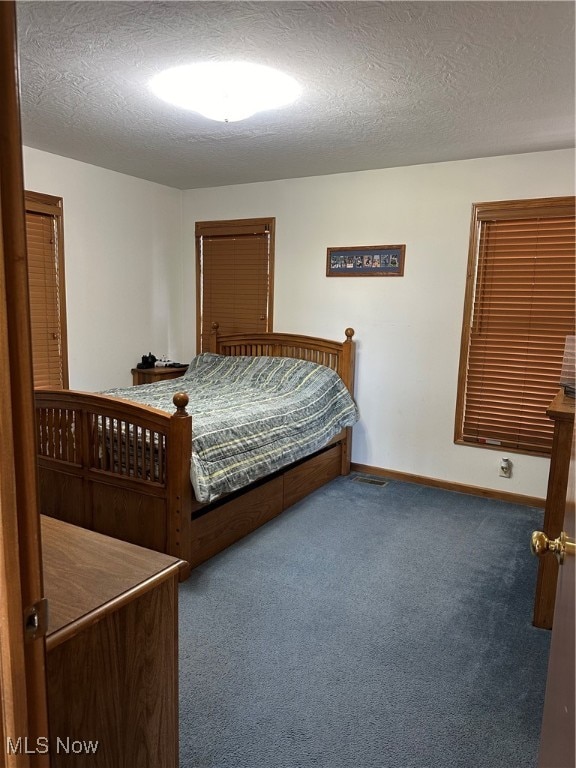 bedroom featuring carpet and a textured ceiling