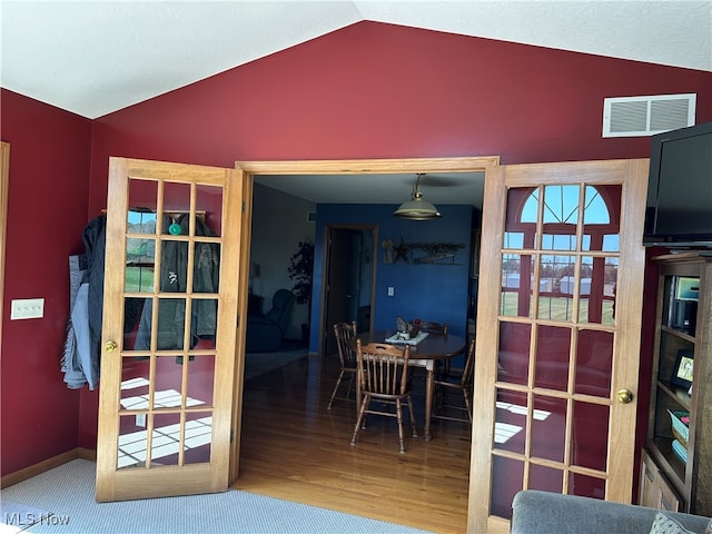 dining room featuring wood-type flooring and vaulted ceiling