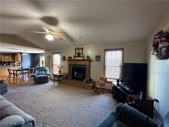 living room featuring lofted ceiling, carpet, and ceiling fan