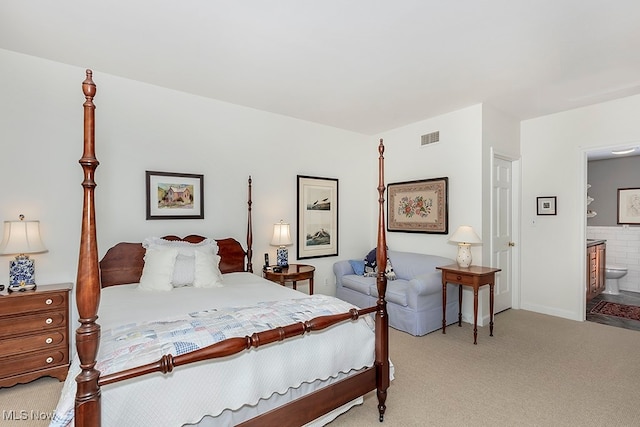 bedroom featuring light carpet and ensuite bathroom