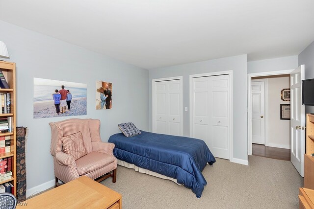 carpeted bedroom featuring two closets