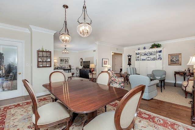 dining room with an inviting chandelier, crown molding, and wood-type flooring