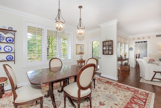 dining room featuring ornamental molding, a chandelier, and dark hardwood / wood-style flooring