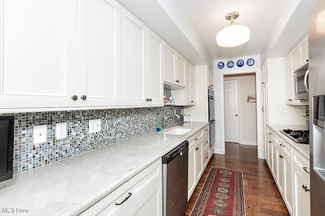 kitchen with sink, dark hardwood / wood-style flooring, white cabinetry, stainless steel appliances, and decorative backsplash