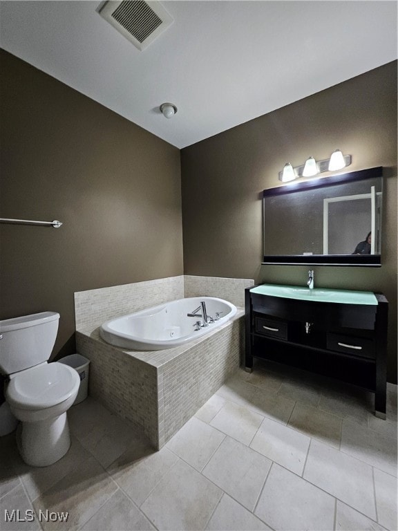 bathroom featuring vanity, toilet, tiled tub, and tile patterned floors