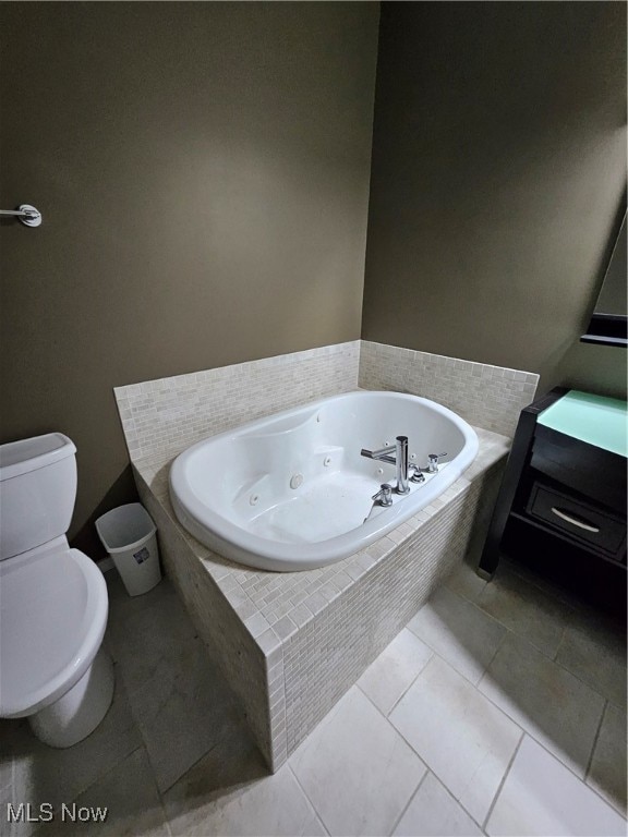 bathroom with vanity, toilet, tiled bath, and tile patterned floors