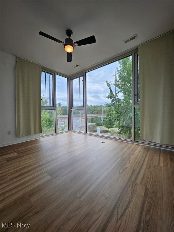 11803 Euclid Ave, Cleveland, OH 44106 - empty room with a ceiling fan, wood finished floors, expansive windows, and healthy amount of natural light