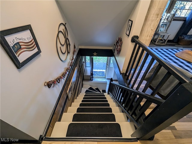 staircase with a high ceiling and hardwood / wood-style flooring