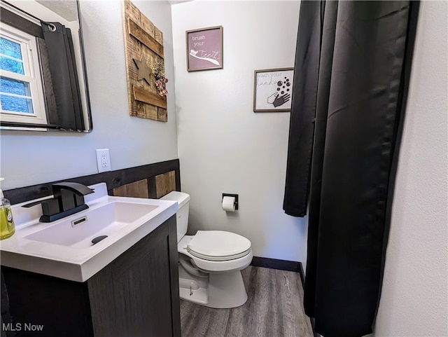 bathroom featuring vanity, toilet, and hardwood / wood-style flooring