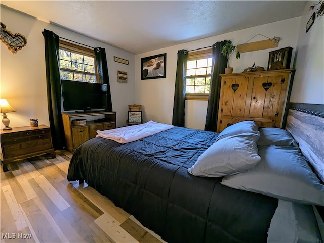 bedroom featuring light hardwood / wood-style floors and multiple windows