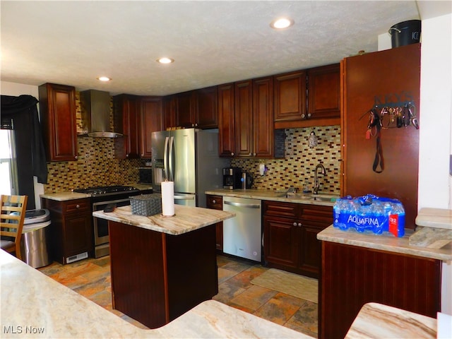 kitchen featuring wall chimney exhaust hood, a kitchen island, appliances with stainless steel finishes, and backsplash