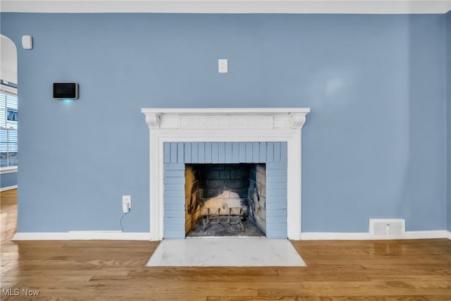 room details featuring hardwood / wood-style floors and a brick fireplace