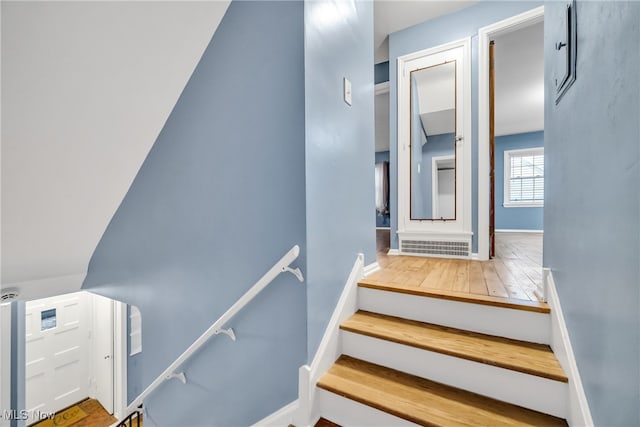 stairs featuring hardwood / wood-style flooring