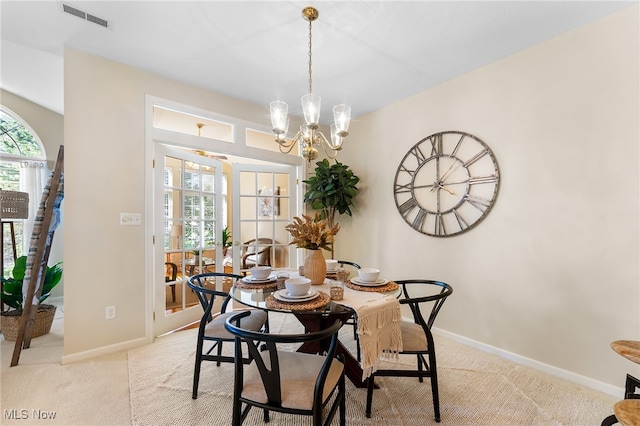 carpeted dining room featuring an inviting chandelier