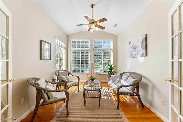 living area featuring lofted ceiling, hardwood / wood-style floors, french doors, and ceiling fan