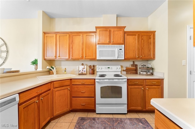 kitchen featuring sink, white appliances, and light tile patterned floors