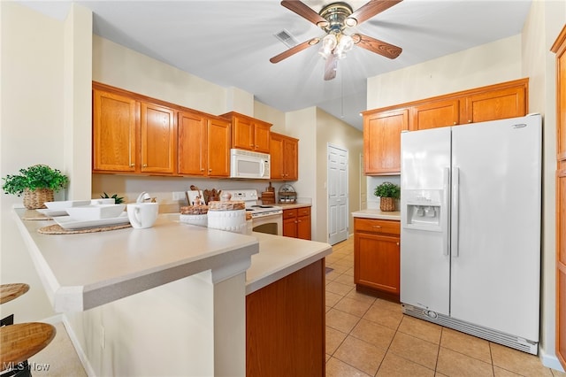 kitchen with a kitchen breakfast bar, kitchen peninsula, light tile patterned flooring, white appliances, and ceiling fan