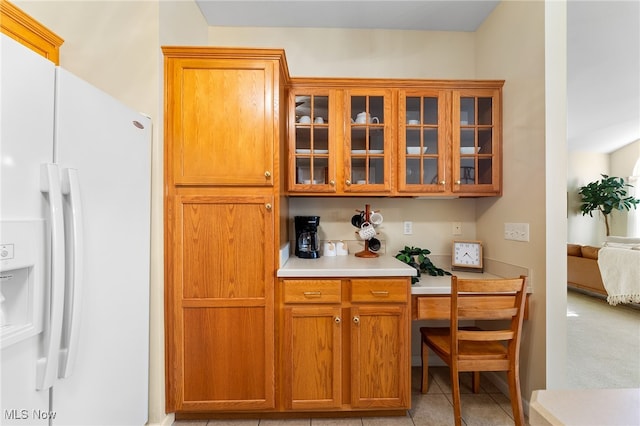 kitchen with white fridge with ice dispenser and light tile patterned flooring