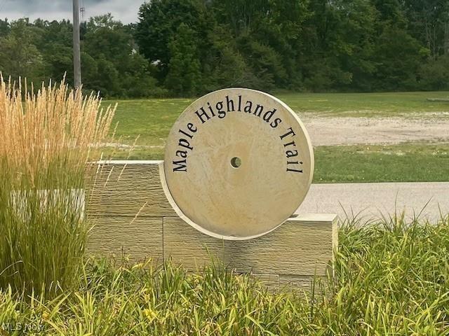community / neighborhood sign with a view of trees