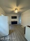 unfurnished living room with dark wood-type flooring and ceiling fan