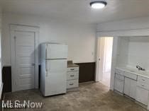 kitchen with white cabinetry and white refrigerator