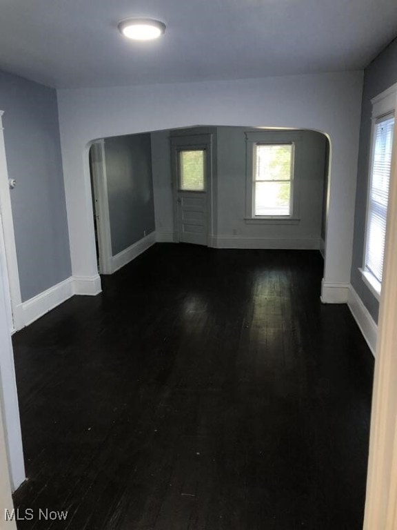 unfurnished room with dark wood-type flooring