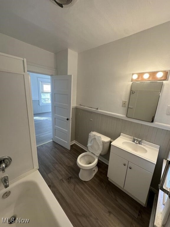 bathroom featuring vanity, hardwood / wood-style flooring, toilet, and a bathing tub