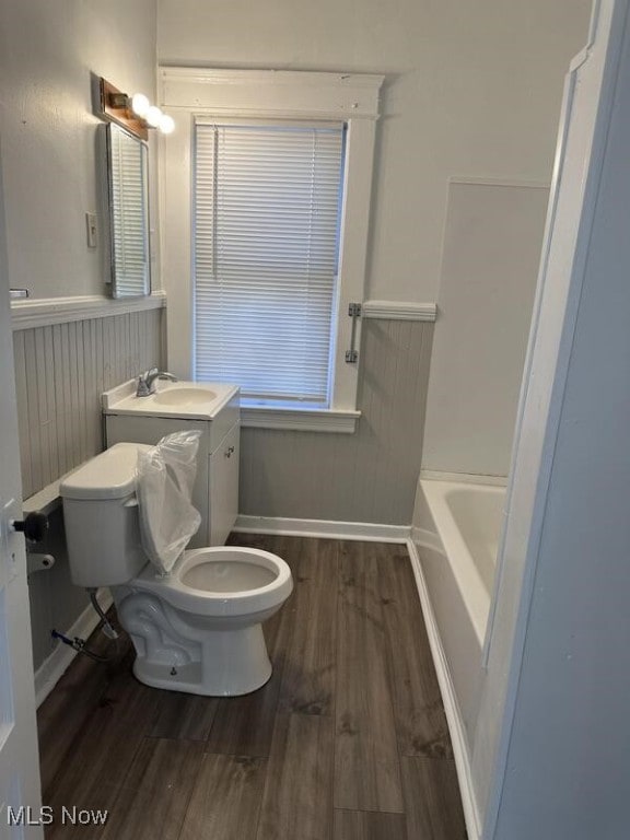 bathroom featuring a bathtub, toilet, wood-type flooring, and vanity