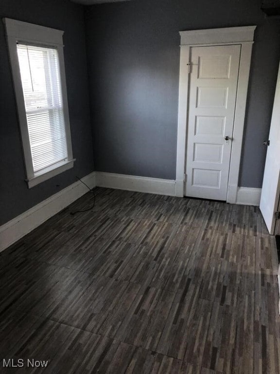 unfurnished room with dark hardwood / wood-style flooring