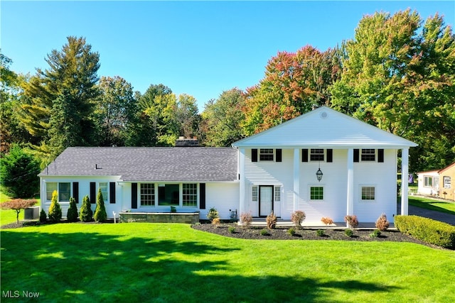 view of front of house featuring a front lawn and central AC unit