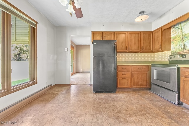 kitchen with decorative backsplash, stainless steel electric range, a baseboard radiator, ceiling fan, and black fridge